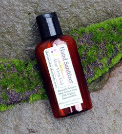 Hand sanitizer bottle with label on a stone surface with green moss